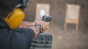 A man holding a firearm pointed at a target