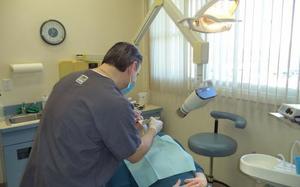 A dentist performing dental work on an elderly patient