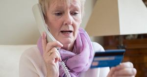 An elderly woman on the phone who has fallen victim to credit card scams
