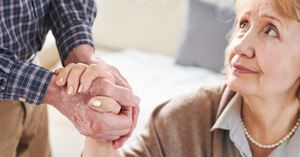 A caregiver managing their stress and maintaining a quality relationship with their loved one by holding her hand