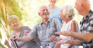 A group of elderly people laughing in a nursing home