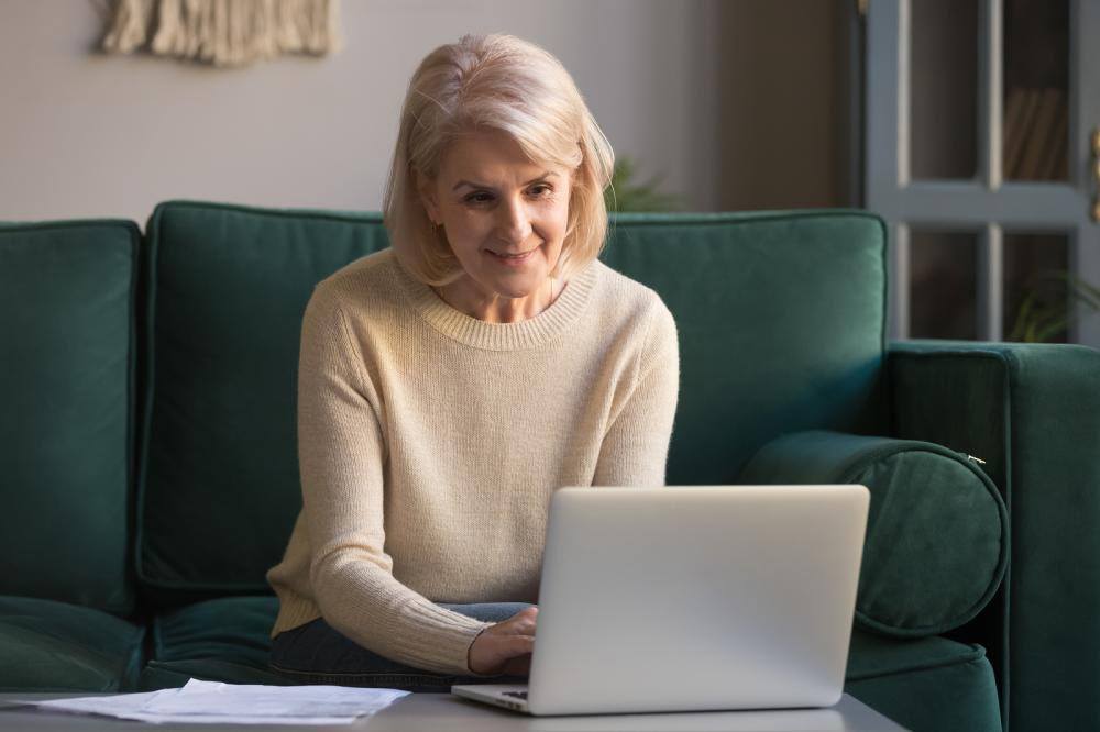 An elderly woman enrolling for medicare on her laptop