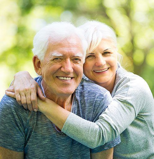 A happy elderly couple hugging