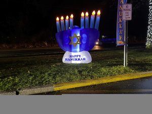 A blow up Menorah that says happy Hanukkah