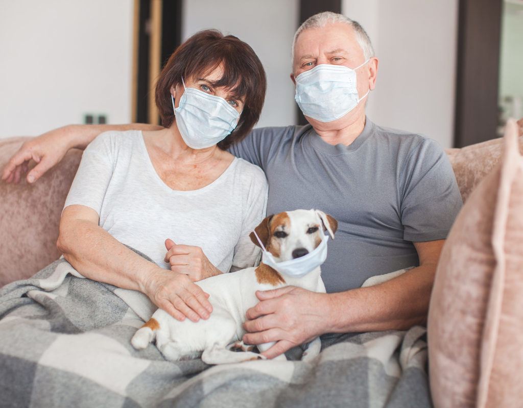 Elderly couple and dog in medical masks during the Coronavirus pandemic
