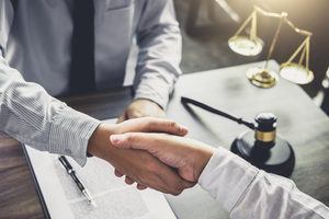 Businessmen shaking hands after winning a Medicaid settlement