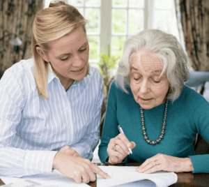 An older woman looking over documents with her elder law attorney